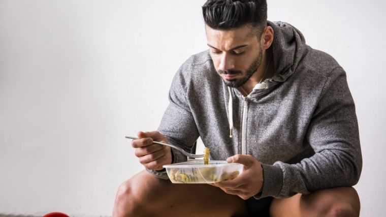 Athlete eating out of tupperware