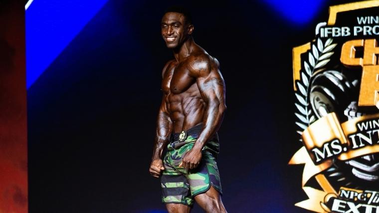 Men's Physique competitor Charjo grant on stage