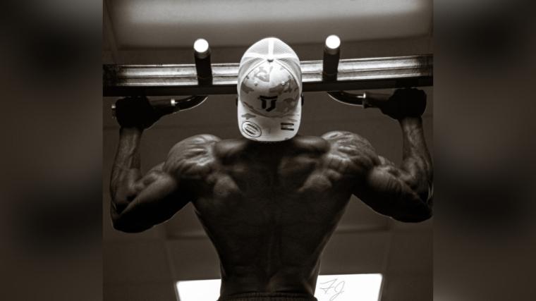 Men's Physique competitor Charjo Grant performing pull-ups
