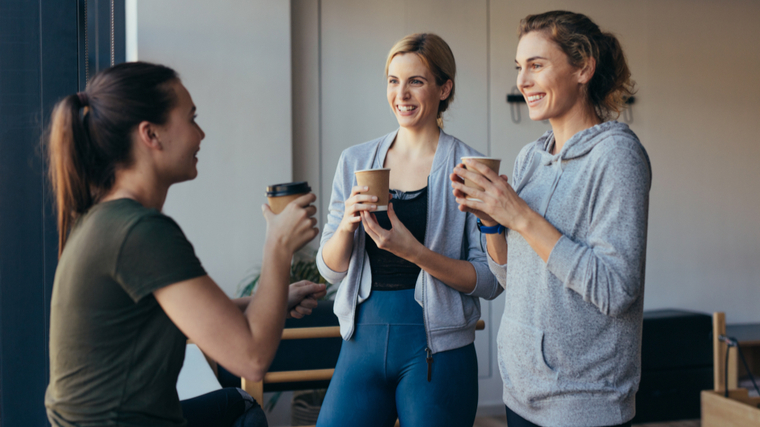 women drinking coffee in yoga studio