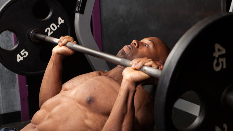 A person performs an incline barbell bench press.