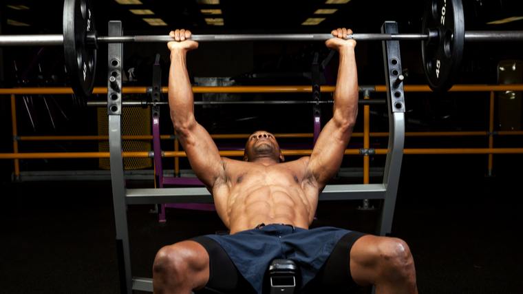 A person sets up to perform an incline barbenll bench press.