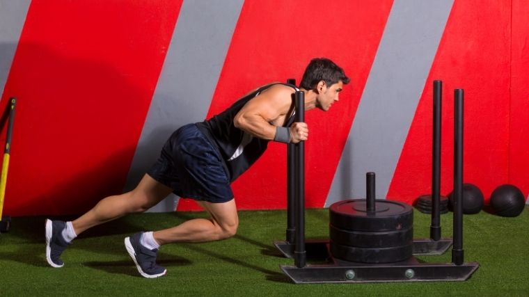 Man pushing a weighted sled