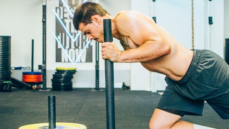 Man gripping a weighted sled