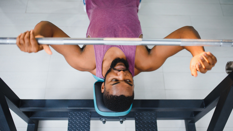 A person sets up for a bench press.