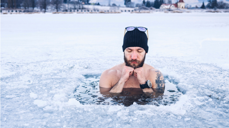 A person stands in an outdoor ice bath.