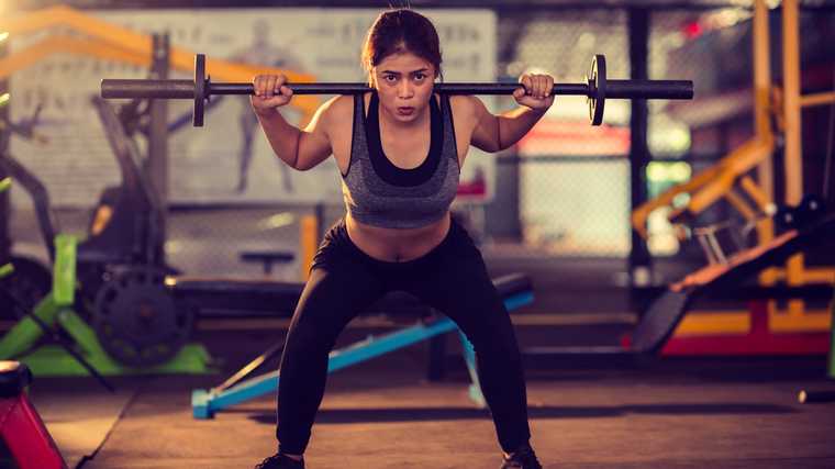 A person performs a barbell squat.