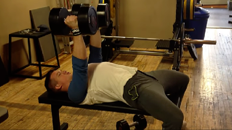 A person completes a neutral-grip dumbbell press.