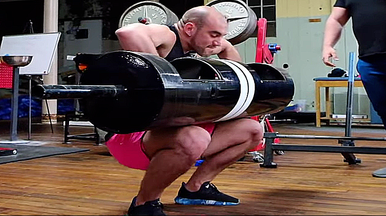 A person wearing pink shorts cleans a log bar into their lap.