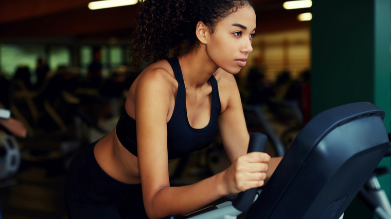 A person focuses while working out on an elliptical.