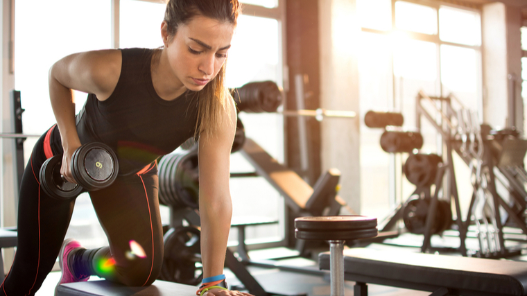 woman performs dumbbell row