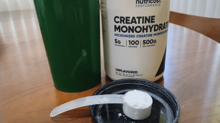 Nutricost Creatine Monohydrate with a scoop of powder. 