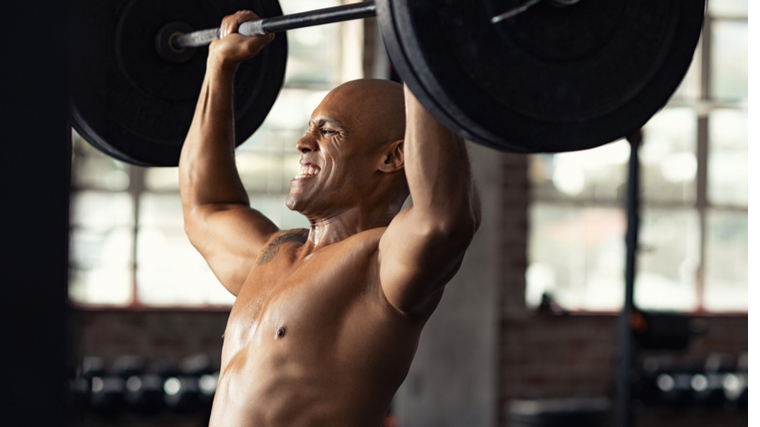 A person pushes through a heavy overhead press.