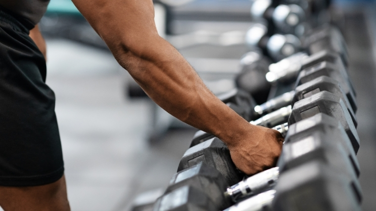 Man grabbing dumbbell