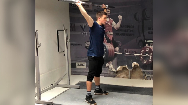  A person establishing position for an overhead squat