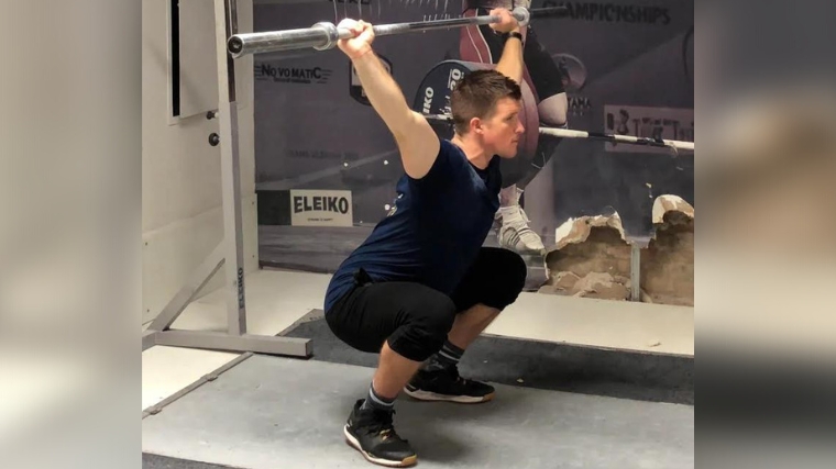A person in an overhead squat position.