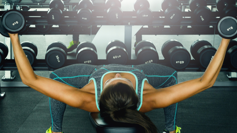 woman performs dumbbell flye 