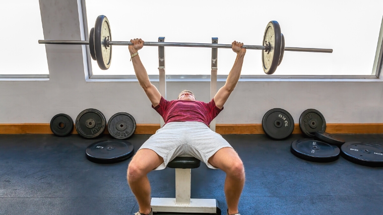 A person performing a barbell bench press.