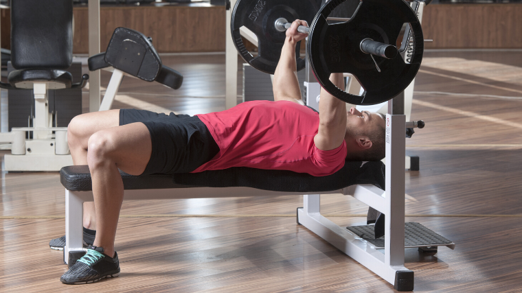 A person positioned to perform a bench press.