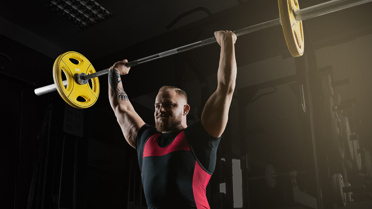 man performs overhead press 