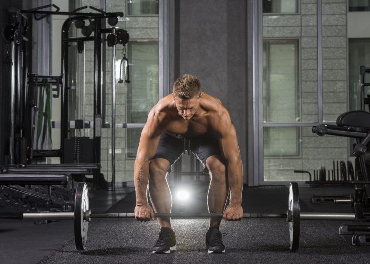 Man holding barbell on floor