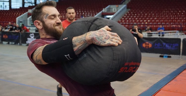 A strongman lifting a heavy bag