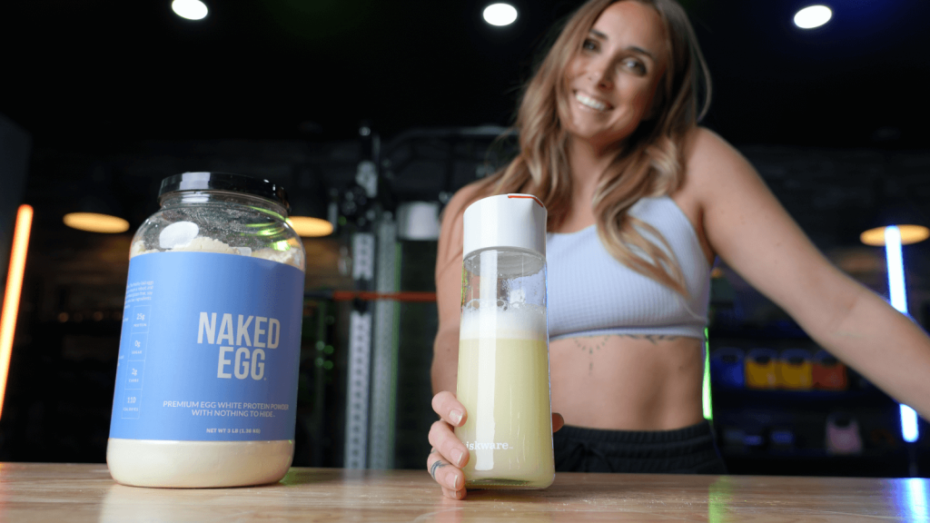 a woman mixing up naked nutrition naked egg protein powder