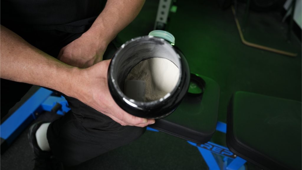 Our tester looking down into a container of Onnit Whey Protein
