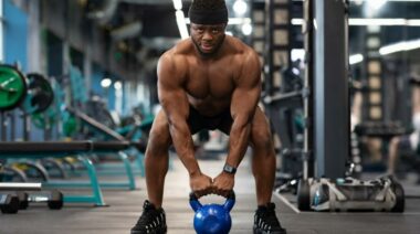 A person prepares to lift a kettlebell in the gym.