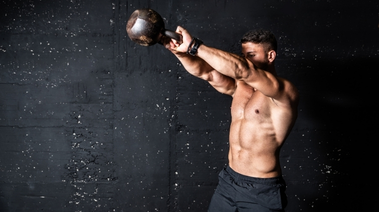 man swinging kettlebell