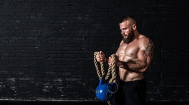 Man curling kettlebell