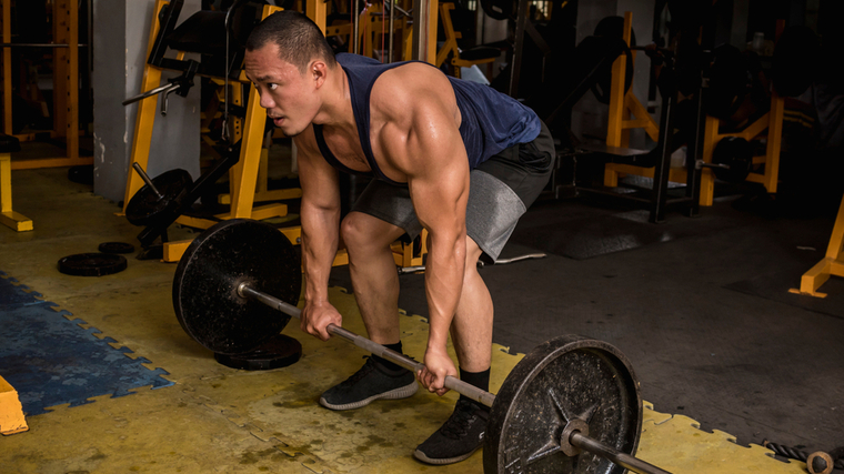 A person prepares to deadlift in the gym.