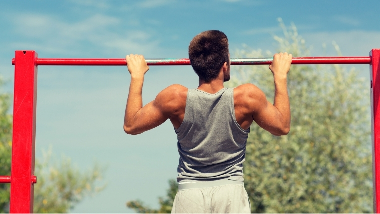 Man performing a pull-up outside