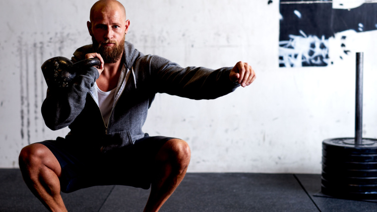 Man doing kettlebell squat clean