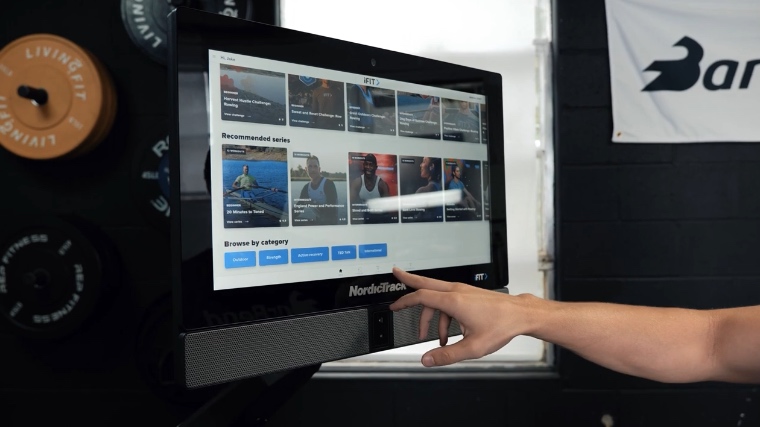 A BarBend tester browsing the iFIT library available through the NordicTrack RW900 Rower