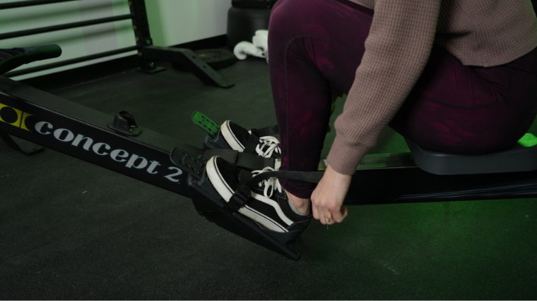 Our tester strapping in their feet on the Concept2 RowErg.