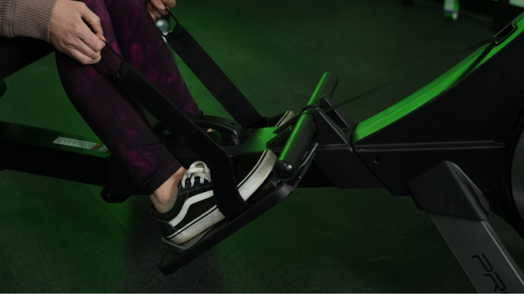 A person slipping into the ProForm 750R rowing machine's foot straps. 