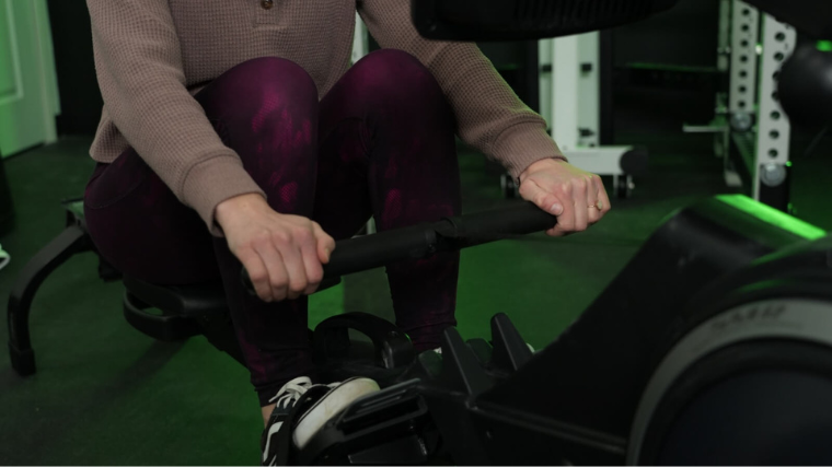 A person gripping the handles of the ProForm 750 R rowing machine.