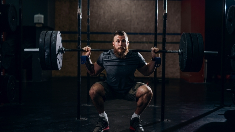 Man squatting with barbell on back