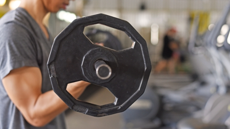 Man curling barbell