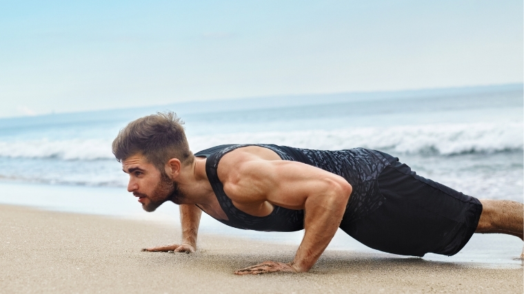 Muscular Bearded Man Stands In Plank Pose Trains Chest And