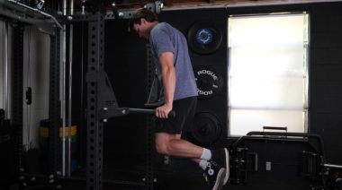 A person performing dips in their gym.