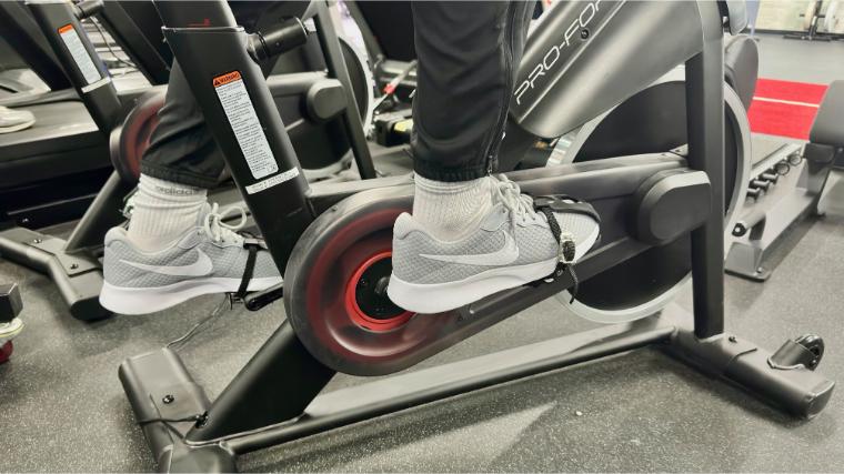 BarBend reviews writer Matt Cummings’ feet strapped into the pedals on the ProForm Studio Bike Pro 22.