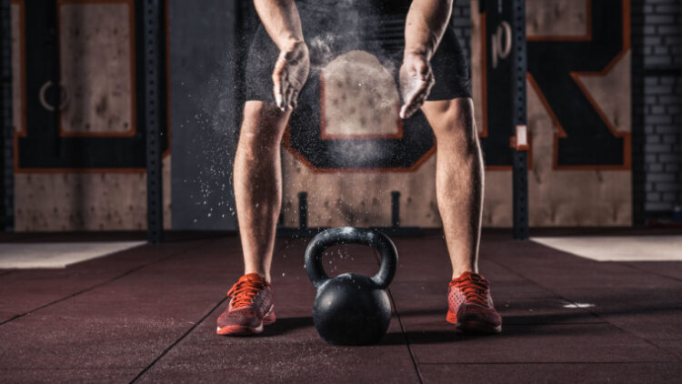 Person readies themselves to lift a kettlebell with chalk