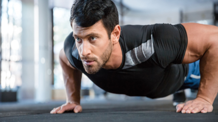 Man focuses intently during push-up exercise