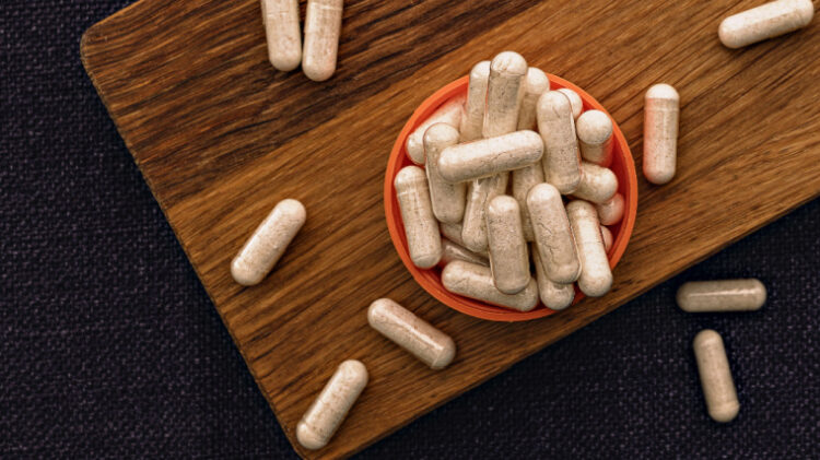 Niacin capsules on a wooden cutting board