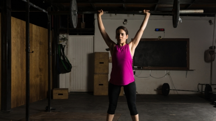 woman performing overhead barbell press