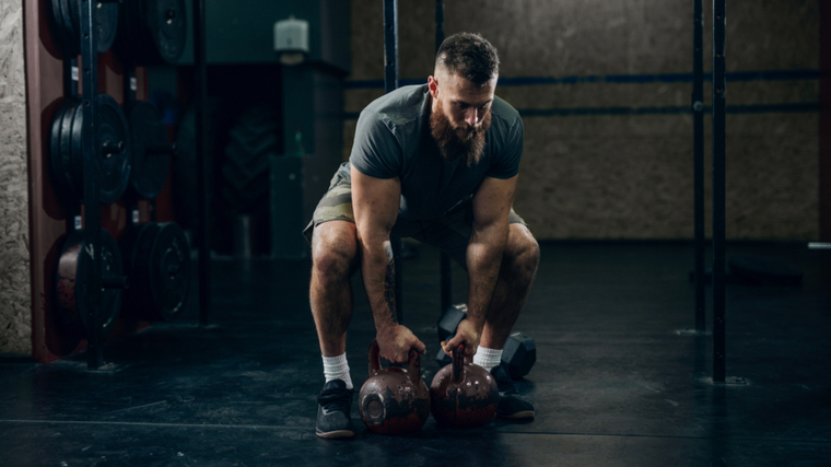 man doing kettlebell sumo deadlift 