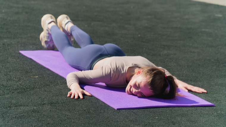 woman laying on mat 