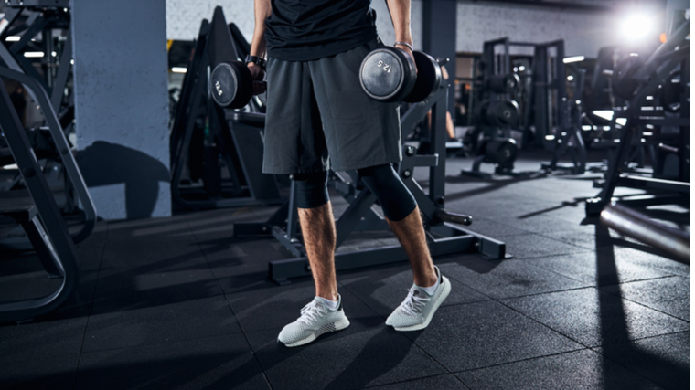 man standing with dumbbells 